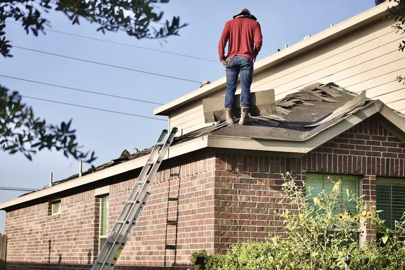 Professional roofer working on a residential roof in Hemlock Hill